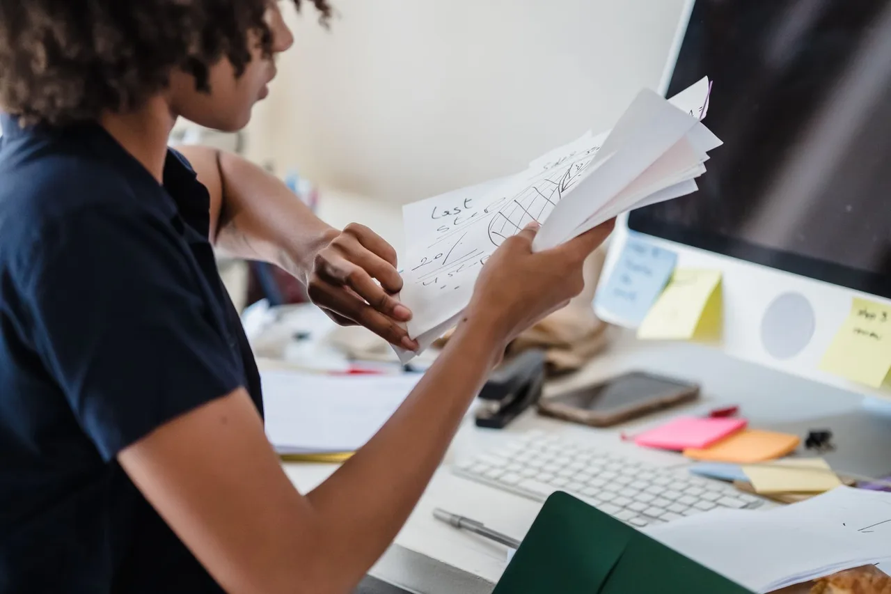 An office worker reviewing and organising documents at a desk