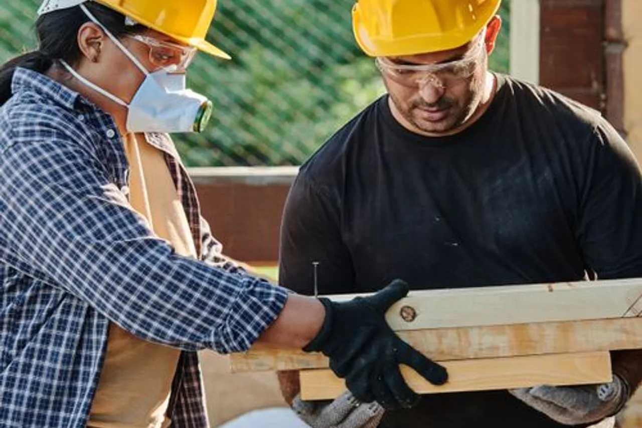Two construction workers wearing hard hats at an outdoor site