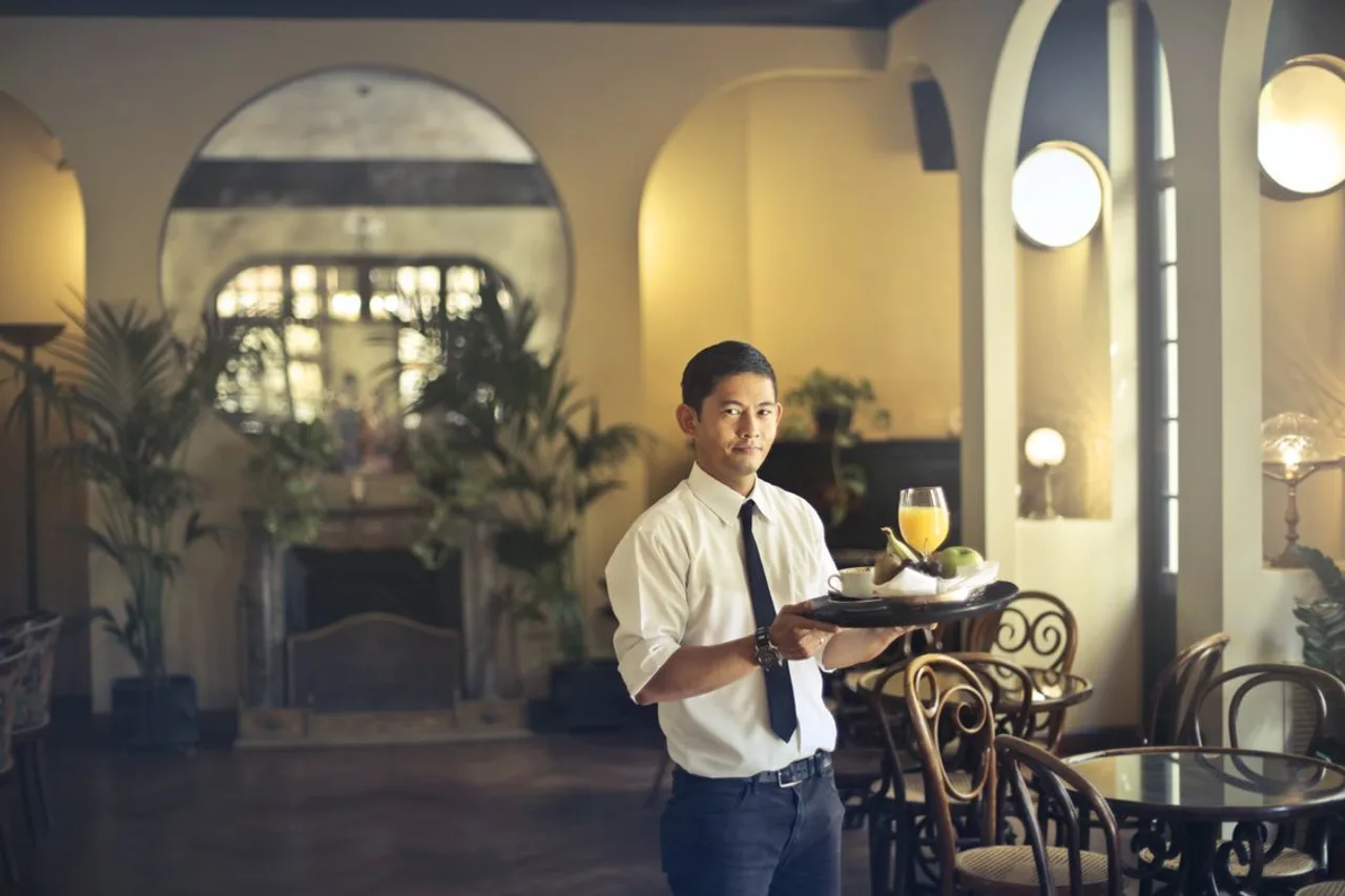 A waiter holding a tray in a restaurant