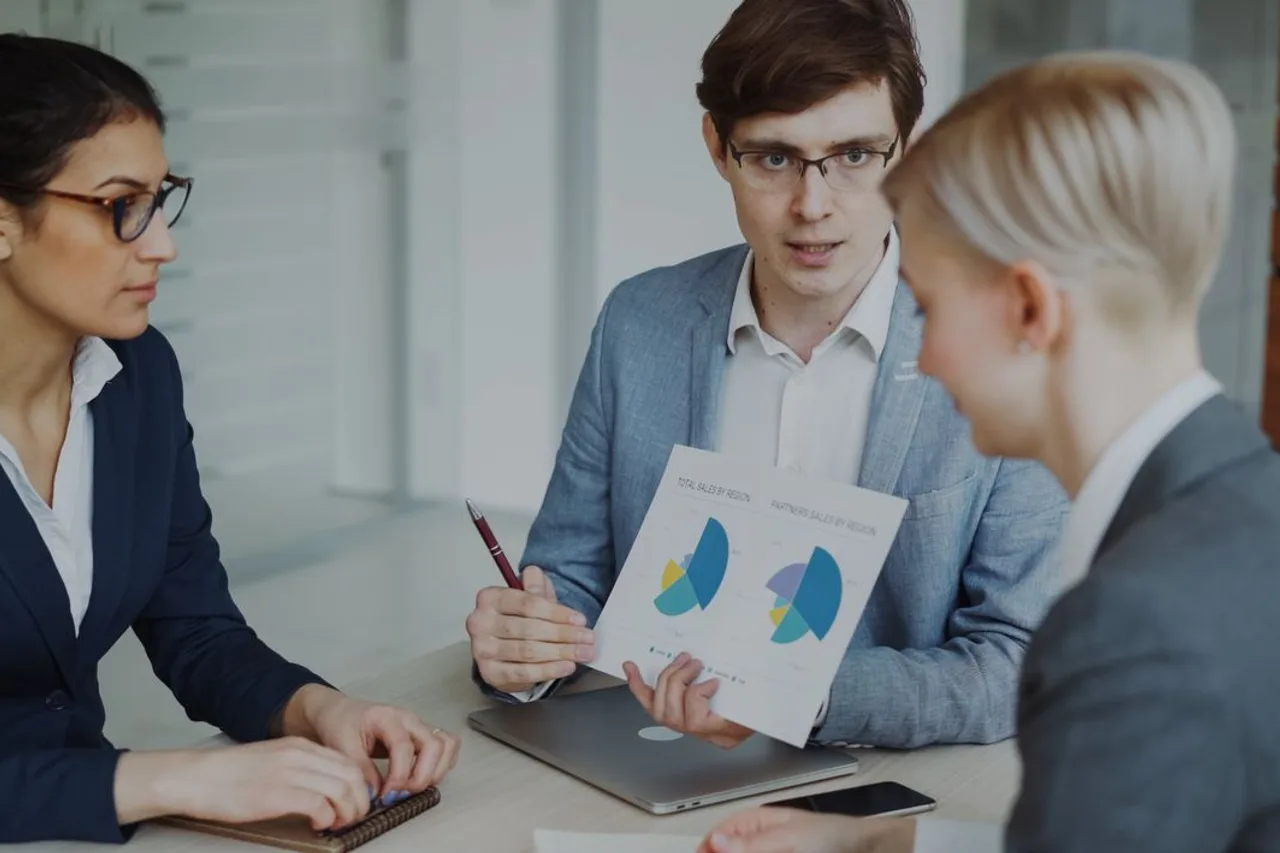A sales team reviewing charts together around a meeting table